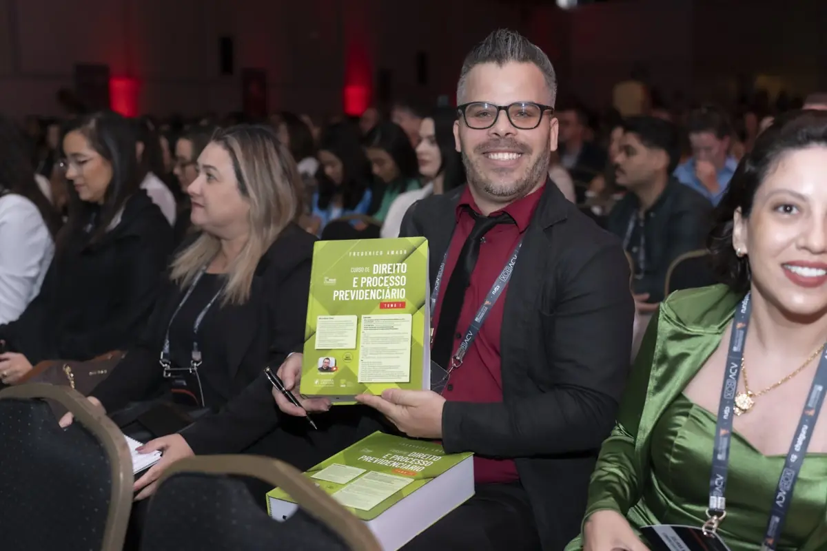 Participante mostra um livro de direito previdenciário durante o evento